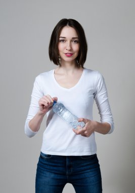 Bir şişe su ile güzel yakın çekim portre genç kadın. Sağlıklı içecek ve spor kavram. Cilt Bakımı ve güzellik. Spor.