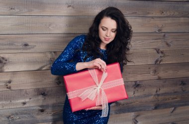 mavi elbiseli genç güzel kız hediye ile ahşap duvar arka plan üzerinde eller