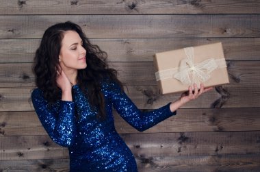 mavi elbiseli genç güzel kız hediye ile ahşap duvar arka plan üzerinde eller