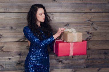 mavi elbiseli genç güzel kız hediye ile ahşap duvar arka plan üzerinde eller