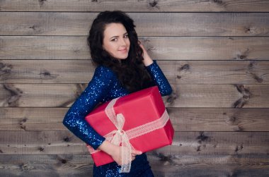 mavi elbiseli genç güzel kız hediye ile ahşap duvar arka plan üzerinde eller