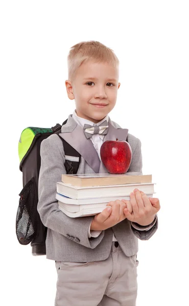 Retrato de colegial sonriente con mochila sosteniendo libro y manzana aislada sobre fondo blanco — Foto de Stock