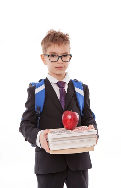 Retrato de colegial sonriente con mochila sosteniendo libro y manzana aislada sobre fondo blanco — Foto de Stock