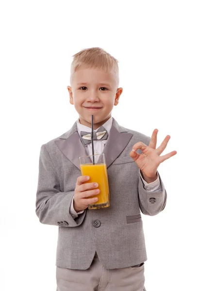 Retrato de un niño bebiendo jugo de naranja. Aislado sobre fondo blanco . — Foto de Stock