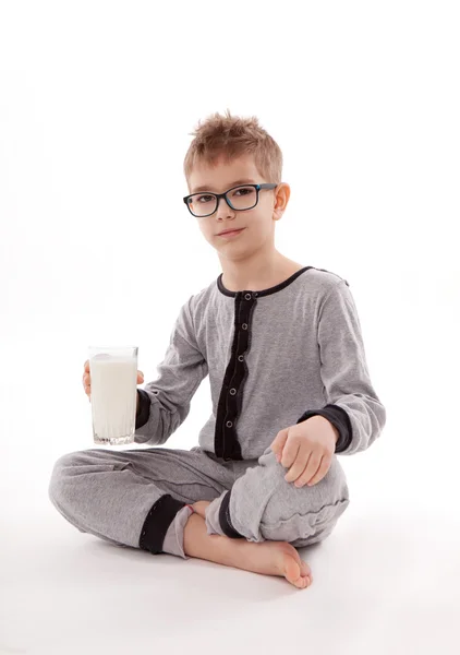 Boy v pyžamu konzumní mléko, na izolované na bílém pozadí — Stock fotografie