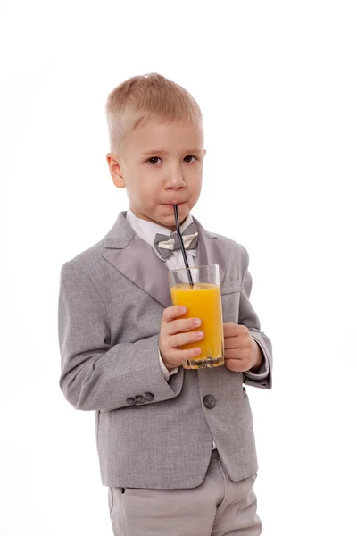 Retrato de un niño bebiendo jugo de naranja. Aislado sobre fondo blanco . — Foto de Stock