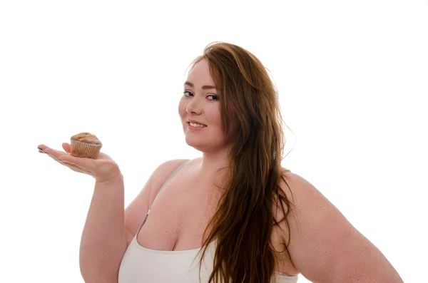 Şişman bir kadın ile bir muffin beyaz arka plan üzerinde izole onun elinde