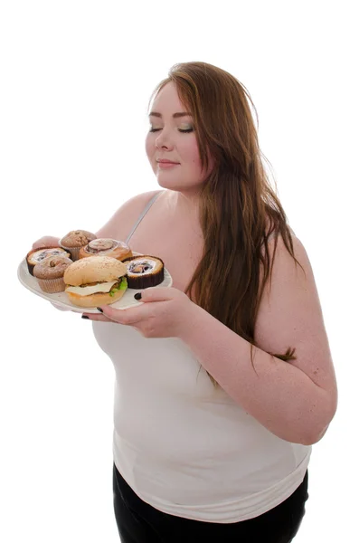Tlustá žena s koláči a hamburgery na podnose v jejích rukou izolovaných na bílém pozadí — Stock fotografie