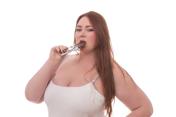 Tlustá žena s čokoládou v ruce izolovaných na bílém pozadí — Stock fotografie