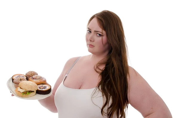 De dikke vrouw met cakes en hamburgers op een schotel in haar handen geïsoleerd op witte achtergrond — Stockfoto