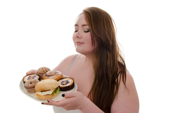 La donna grassa con torte e hamburger su un piatto in mano isolato su sfondo bianco — Foto Stock