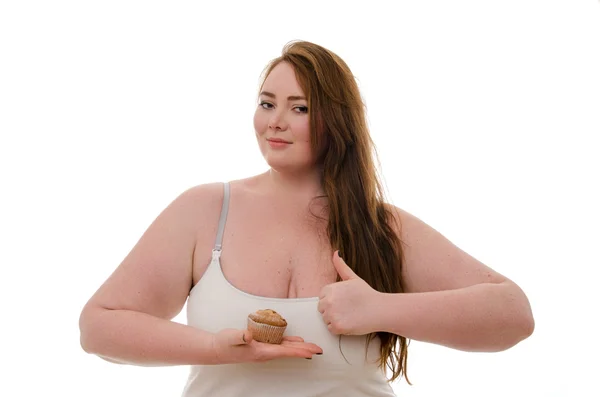 Una donna grassa con un muffin in mano isolato su sfondo bianco — Foto Stock