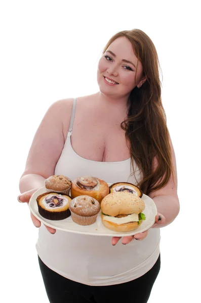 La donna grassa con torte e hamburger su un piatto in mano isolato su sfondo bianco — Foto Stock