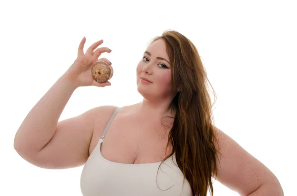 Tlustá žena s muffin v ruce izolovaných na bílém pozadí — Stock fotografie