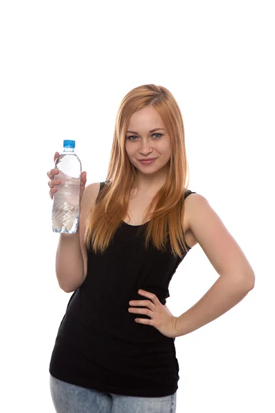 Mladá krásná dívka s rudými vlasy drží láhev vody v ruce izolované na bílém pozadí — Stock fotografie