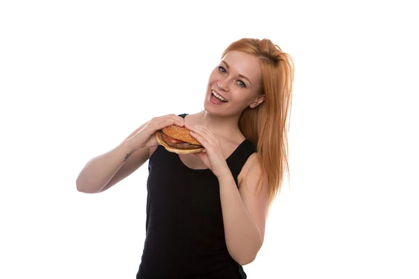 Joven hermosa chica con el pelo rojo sosteniendo una hamburguesa en sus manos aislado sobre fondo blanco — Foto de Stock