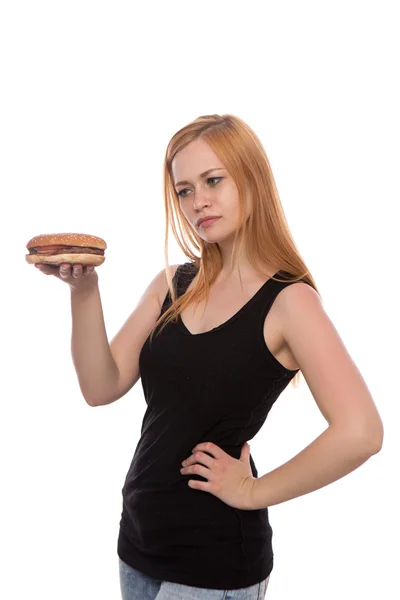 Joven hermosa chica con el pelo rojo sosteniendo una hamburguesa en sus manos aislado sobre fondo blanco — Foto de Stock