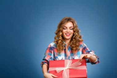 bir kutu içinde kırmızı bir Noel hediye paketi ile genç kız