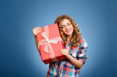 bir kutu içinde kırmızı bir Noel hediye paketi ile genç kız