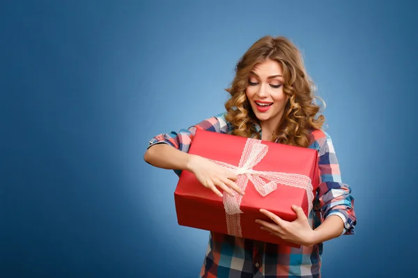 Jong meisje met een doos in een rode kerst cadeau arrangement — Stockfoto