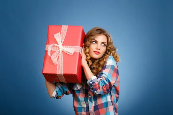 Jong meisje met een doos in een rode kerst cadeau arrangement — Stockfoto