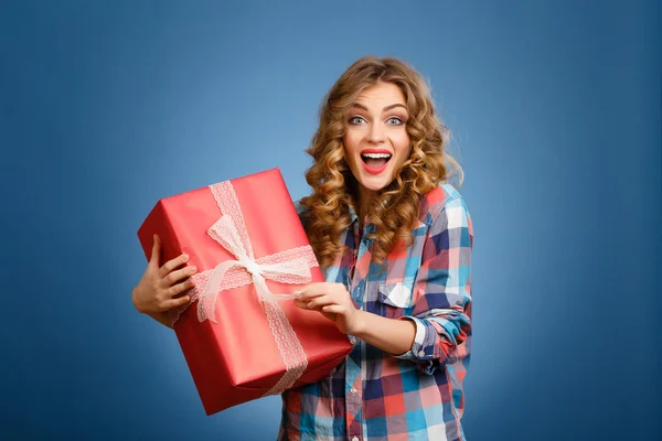 Jong meisje met een doos in een rode kerst cadeau arrangement — Stockfoto