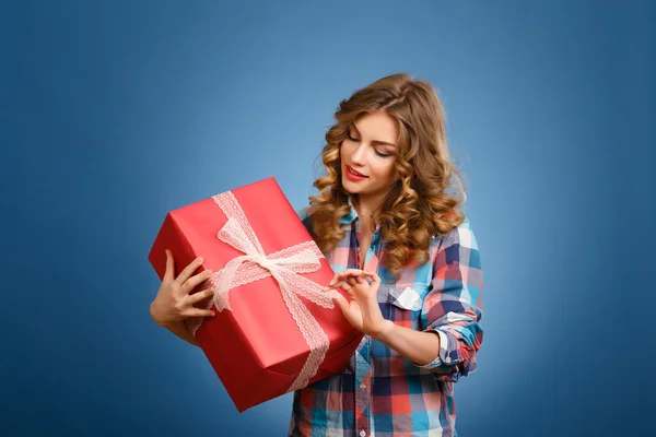 Jong meisje met een doos in een rode kerst cadeau arrangement — Stockfoto