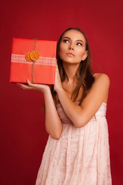 Mooi jong meisje met een doos verpakt in cadeau papier — Stockfoto