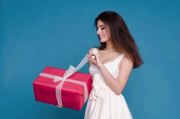Mooi meisje in een witte jurk met een gift — Stockfoto