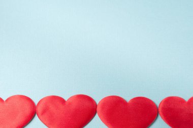 Mavi arka planda dört kalp. Kalpler çerçevenin altında..