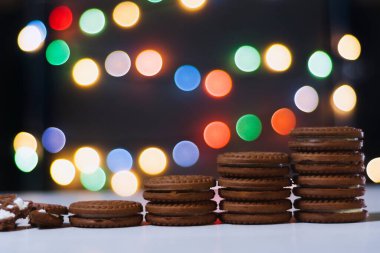 Çikolatalı vanilyalı kurabiyeler renkli bokeh 'in arka planında merdiven gibi duruyor. Kurabiye merdiveni kariyer merdivenini simgeler..