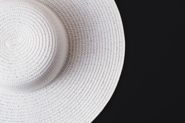A large white beach lady's hat on a black background. The concept of vacation, vacation, travel, sales, black Friday.