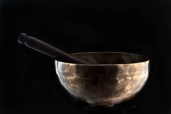 Bronz tenli, siyah arka planda Tibet kasesi söylüyor..