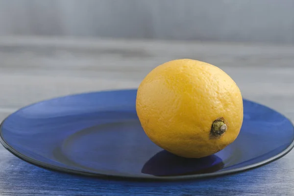 Gelbe Zitrone Auf Blauem Glasteller — Stockfoto