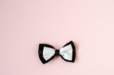 Pastel pembe renkte siyah beyaz papyon. Arka planı kopyala.