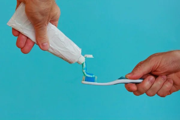 Um homem bate no tubo de pasta de dentes — Fotografia de Stock