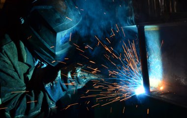 Fabrikada çalışan kaynakçılar metal üretiyorlar.