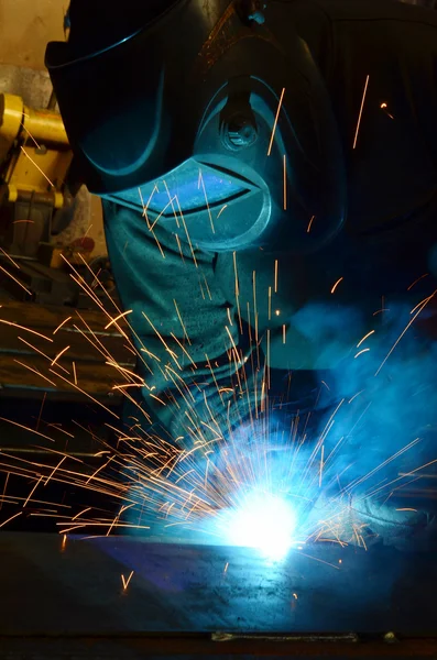 Fabrikada çalışan kaynakçılar metal üretiyorlar.
