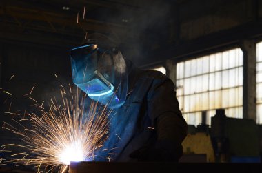 Fabrikada çalışan kaynakçılar metal üretiyorlar.