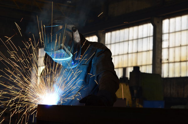 Welders working at the factory made metal