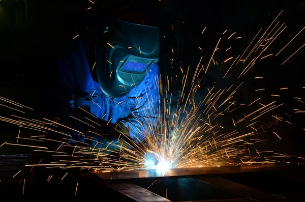 Fabrikada çalışan kaynakçılar metal üretiyorlar.