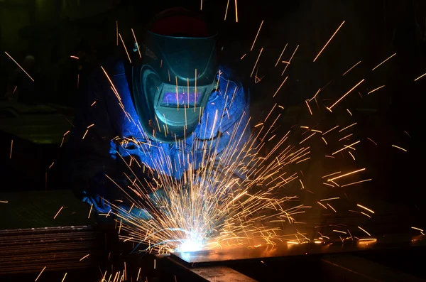 Fabrikada çalışan kaynakçılar metal üretiyorlar.