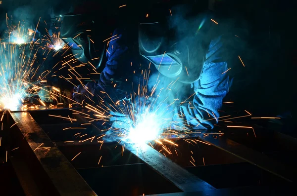 Fabrikada çalışan kaynakçılar metal üretiyorlar.