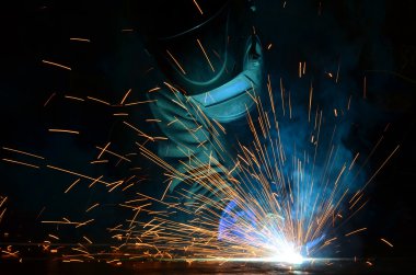 Fabrikada çalışan kaynakçılar metal üretiyorlar.
