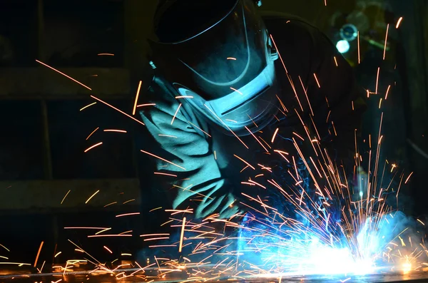 Fabrikada çalışan kaynakçılar metal üretiyorlar.