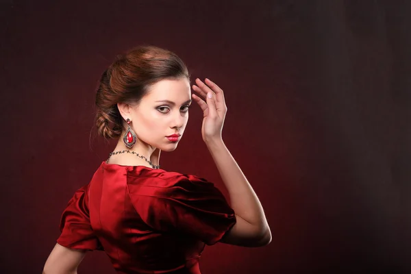 Belle femme en robe rouge avec maquillage professionnel — Photo