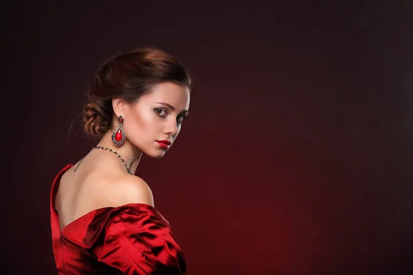 Belle femme en robe rouge avec maquillage professionnel — Photo