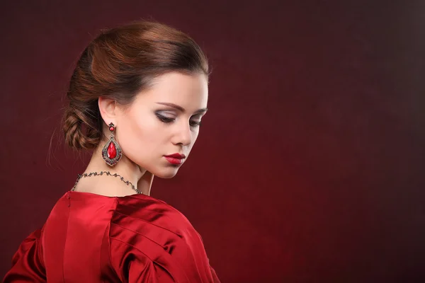 Όμορφη γυναίκα στο κόκκινο φόρεμα με ΕΠΑΓΓΕΛΜΑΤΙΚΟ ΜΑΚΙΓΙΑΖ — Φωτογραφία Αρχείου