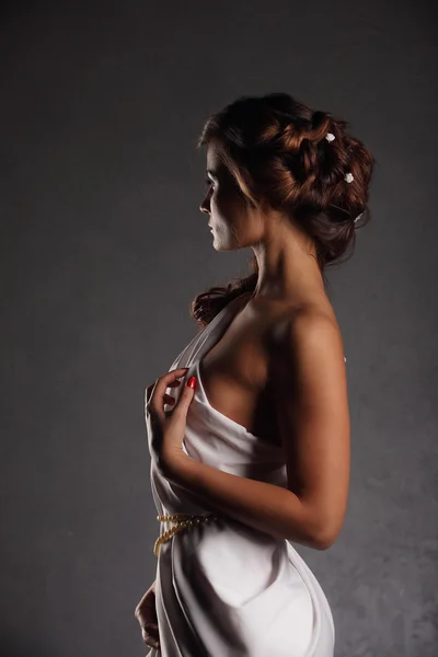 Portret mooie vrouw met elegante witte jurk grunge muur achtergrond — Stockfoto