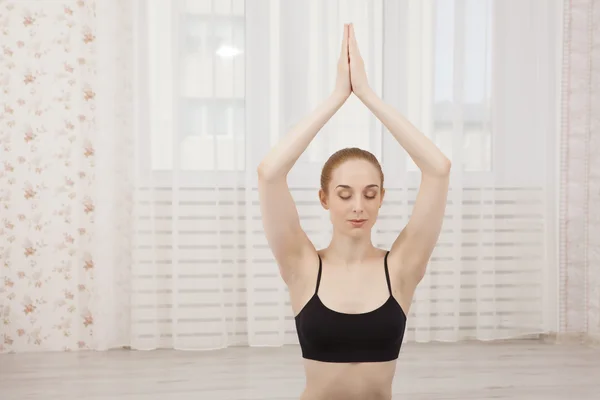 Schöne junge Frau praktiziert Yoga zu Hause auf Matte - Meditation — Stockfoto